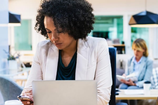 Eine Frau mit Notebook und Smartphone